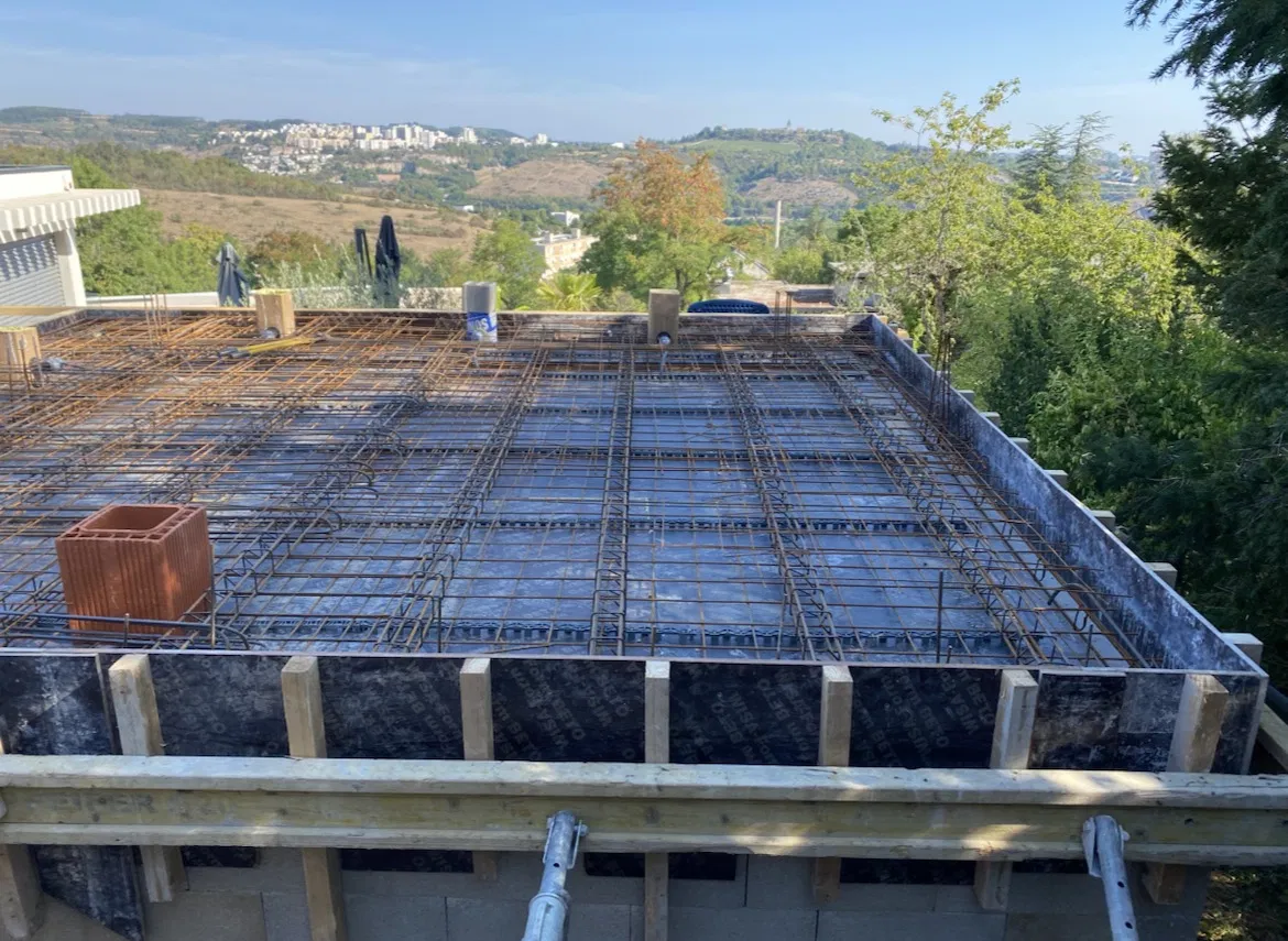 Chantier maçonnerie — dalle béton ferraillée en cours de coulage